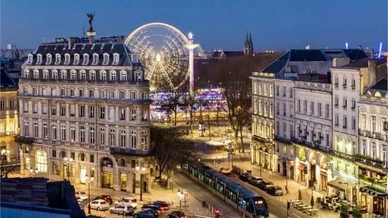 Illustration de bordeaux la belle endormie avec le tram, le quartier du triangle d'or le cours de l'intendance, la place des quinconces, vue sur la fête foraine
