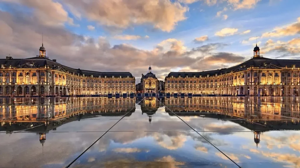 Illustration de la place de la bourse à bordeaux avec le miroir d'eau et le reflet du ciel et des bâtiments dans le miroir